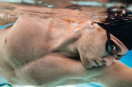 Young male athlete swimming in pool