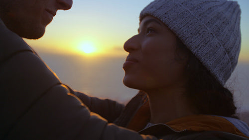Romantic couple admiring the sunset over the sea