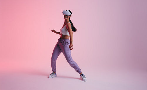 Happy young woman dancing in the metaverse