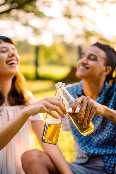 Smiling young couple toasting beer bottles