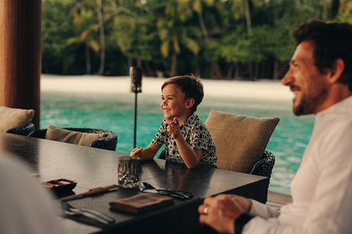 A family enjoying a meal together at a scenic beachside setting