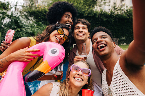 Friends enjoy a sunny outdoor party with inflatable flamingo