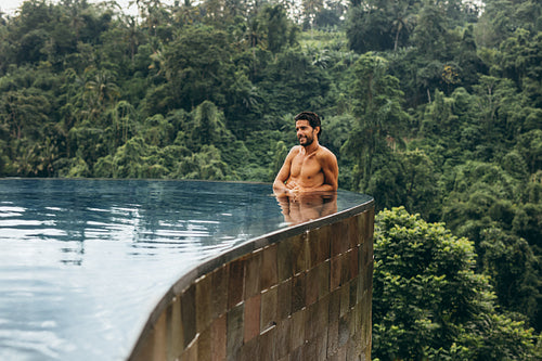 Relaxed young man standing in a swimming pool
