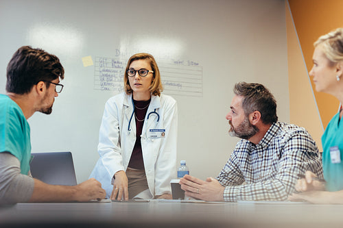 Female doctor briefing hospital staff during meeting