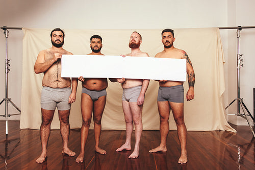 Activists holding up a white banner in a studio
