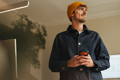 Man holds a smartphone in the office during a business workday portrait