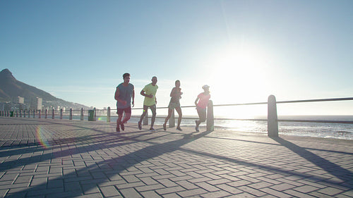 Group of people running on ocean front