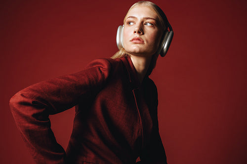 The woman presents a business portrait with headphones and confident studio style