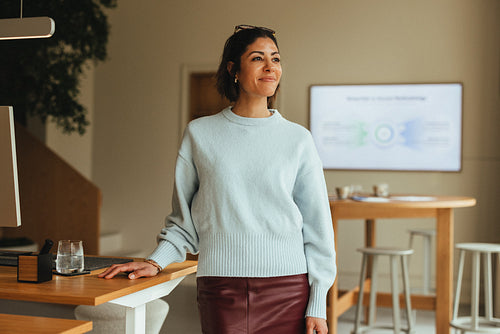 Woman standing in office for business portrait near a meeting table