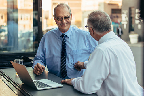 Senior businessmen having casual talk at cafe after work
