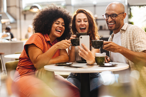 Friends taking a selfie with coffee cups at a social gathering