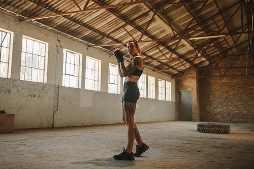 Woman shadow boxing in empty warehouse