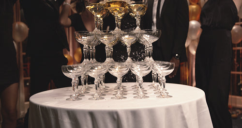 Woman filling champagne in glasses pyramid at party