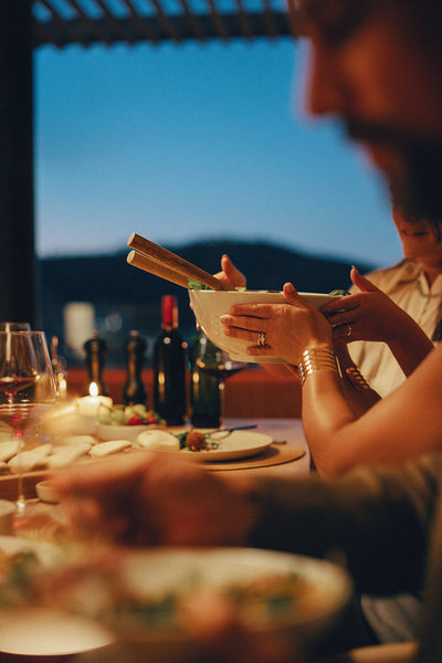 Evening dinner scene with close friends sharing dishes and enjoying a cozy atmosphere
