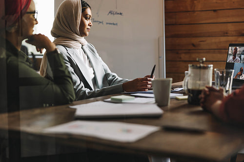 Female entrepreneurs attending an online meeting in an office