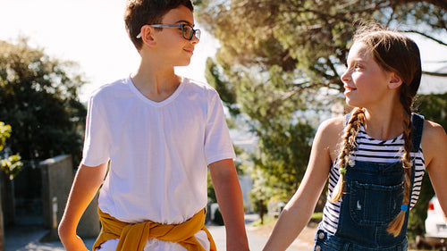 Kids walking on street together on a sunny day