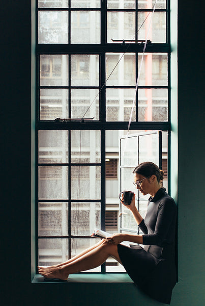 Young woman reading book with coffee