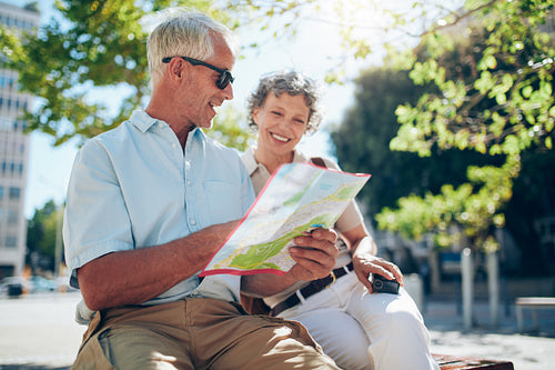 Senior tourist looking for a place on the map