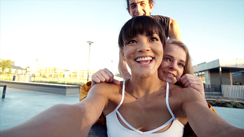 Cheerful skaters taking a fun selfie video in an urban skate park