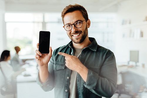 Man recommending a mobile phone in an office