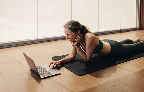 Elderly woman joining an online fitness class on a laptop