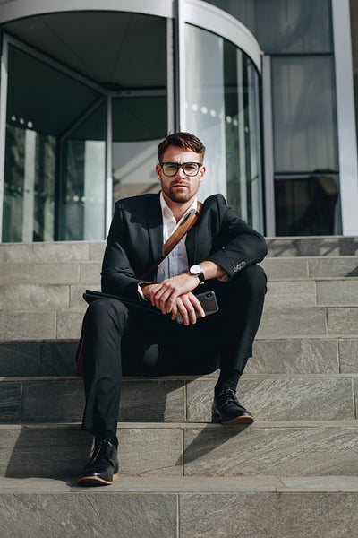 Businessman sitting on steps outdoors on a sunny day