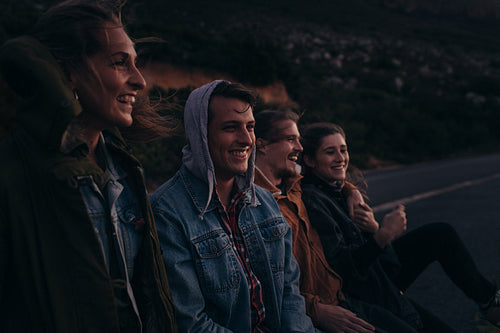 Group of friends sitting on a highway