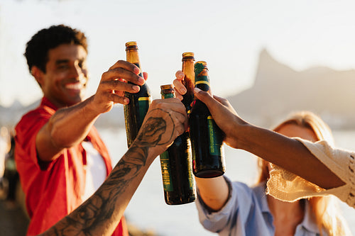 Friends toasting with beers in Rio de Janeiro at sunset