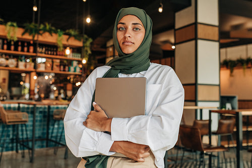 Young woman with a hijab standing in a coffee shop