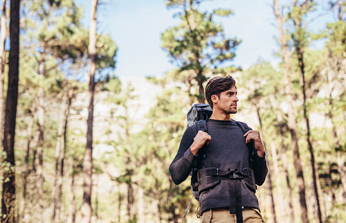Man hiking in forest wearing a backpack