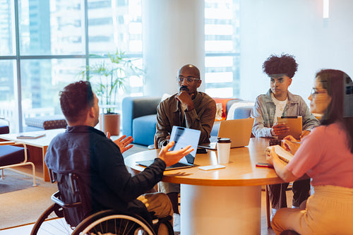 Meeting of colleagues around a roundtable in modern office