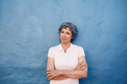 Beautiful senior woman standing with her arms crossed