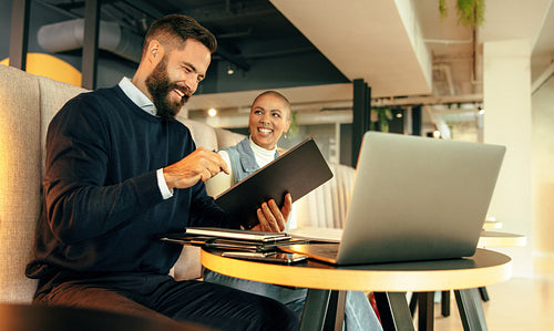 Two happy businesspeople working together in a co-working space
