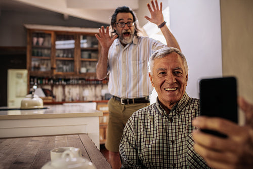 Elderly men enjoying taking selfie with mobile phone
