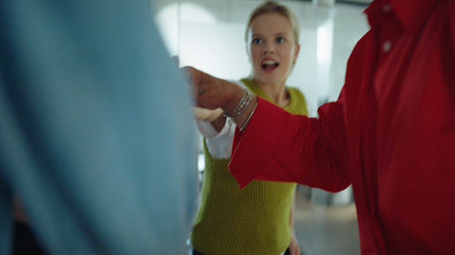Team celebrates success with coworkers in an office huddle