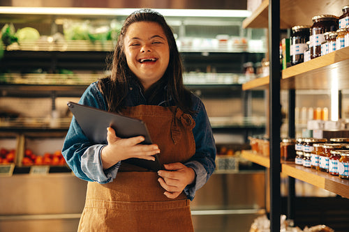 Convenience store employee with Down syndrome laughing happily