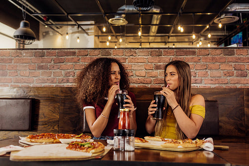 Best friends drinking cola at restaurant