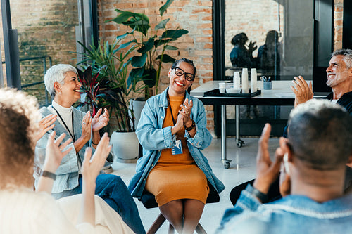 Colleagues clapping and praising during a team workshop