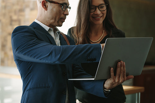 Business partners in office working on a laptop