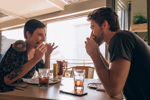 Couple having burger at restaurant