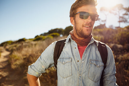 Happy young man hiking in countryside