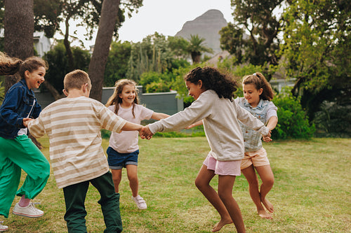 Children playing together happily outdoors in a sunny green park