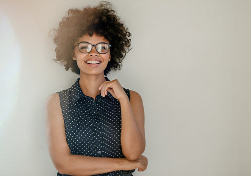 Beautiful woman in casuals standing by a wall