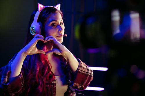 Gamer doing a heart gesture in front of a recording camera