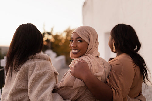 Happy muslim woman walking with her friends outdoors