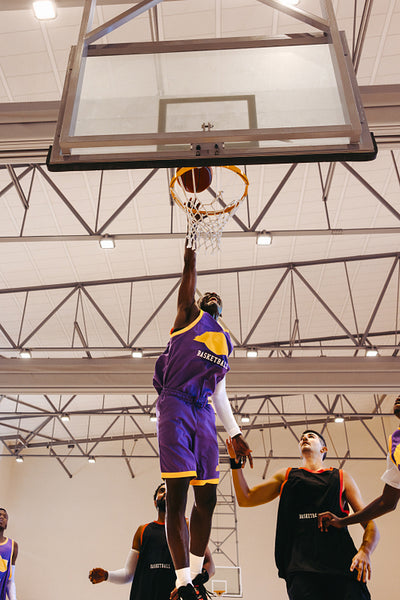 Players competing in basketball match indoors