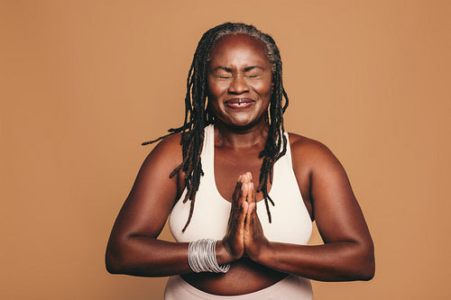 Cheerful black woman meditating in a studio
