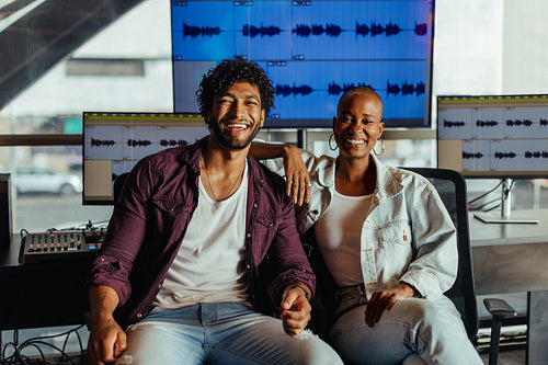 Happy creative professionals enjoying a break in modern sound studio