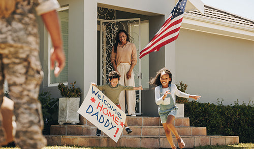 Joyful young children welcoming their father from the military
