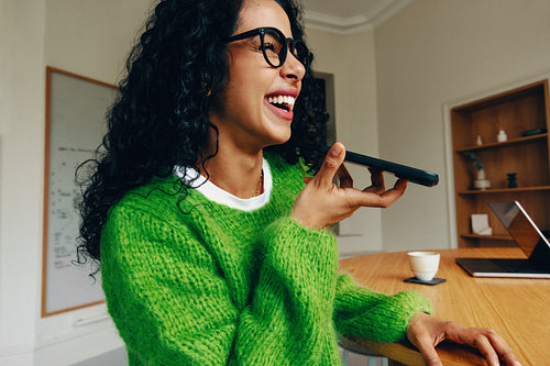 Joyful woman using smartphone in modern business office